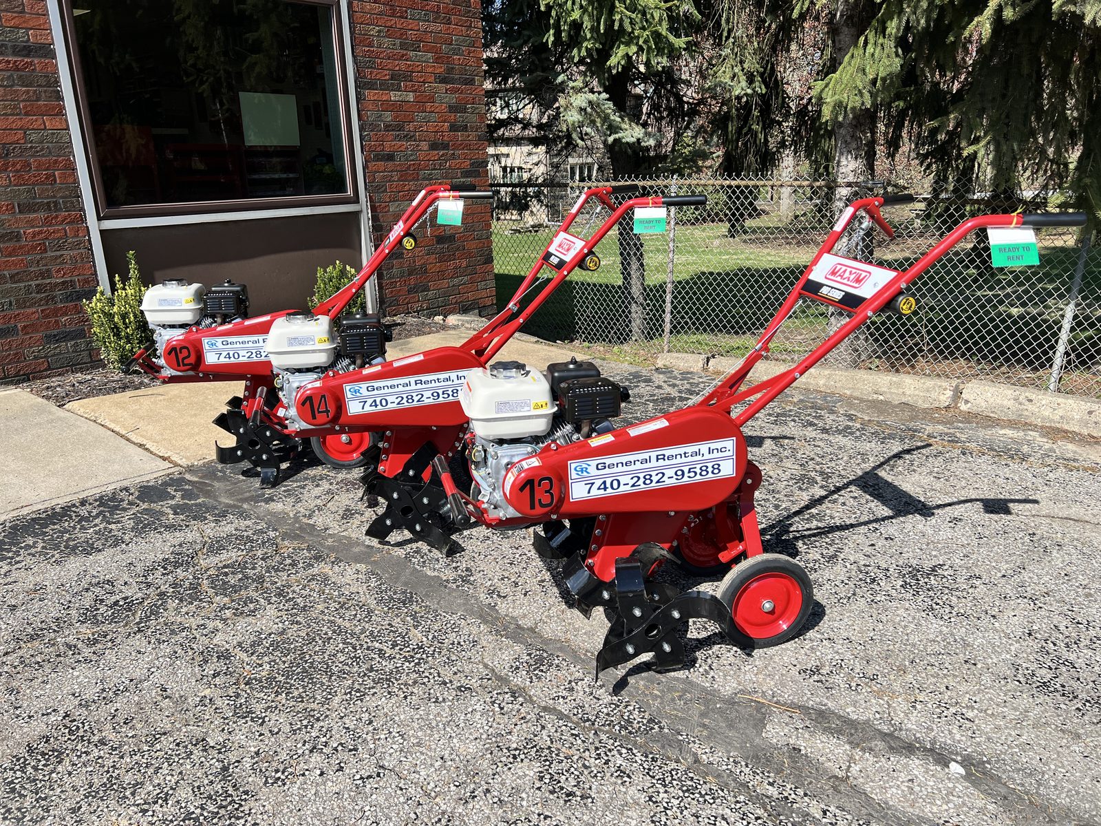 Three red Maxim Pro Series rear-tine tillers with General Rental decals lined up at the Steubenville yard