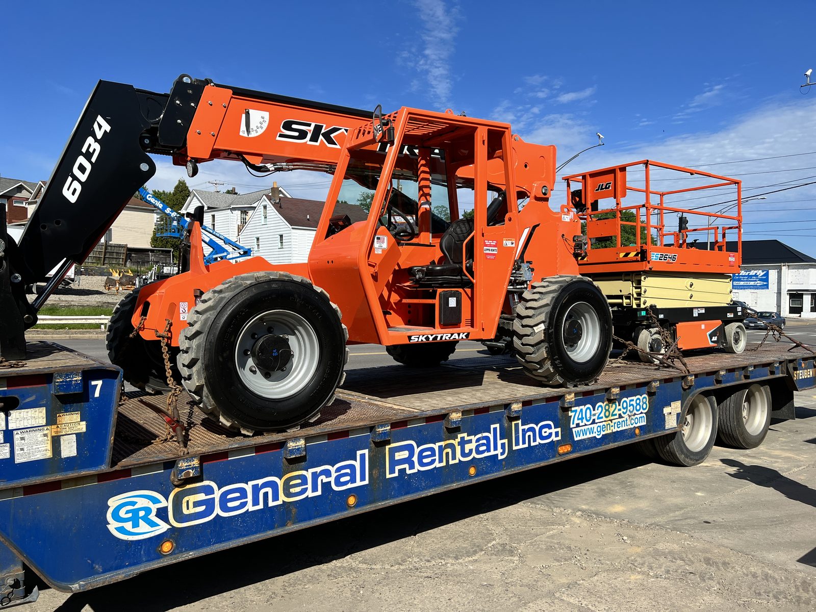 SkyTrak 6034 telehandler and JLG 2646 scissor lift loaded on a General Rental delivery trailer
